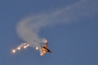 BAF F-16AM solo display dispensing flares in the evening